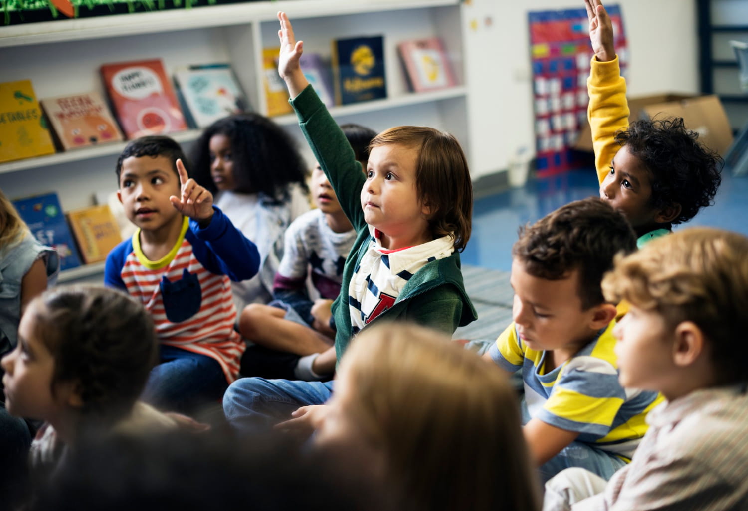 Child putting hand up in school
